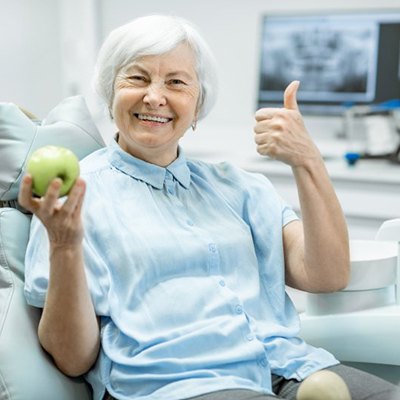 Patient holding an apple and making a thumbs-up