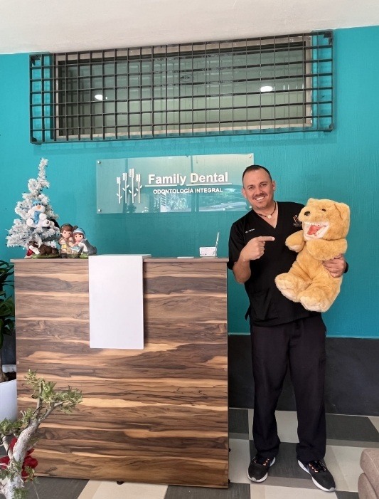 Merrillville dentist holding a teddy bear with a set of false teeth