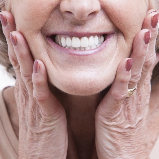 Close up of smiling senior woman with her hands on her cheeks