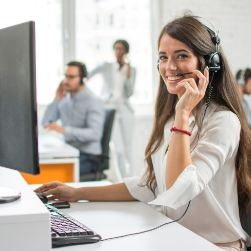 Smiling woman talking on phone at a call center