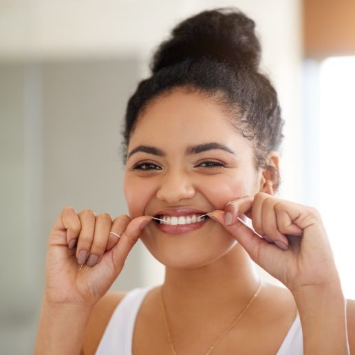 Young woman smiling while flossing