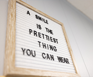 Indoor sign that says a smile is the prettiest thing you can wear