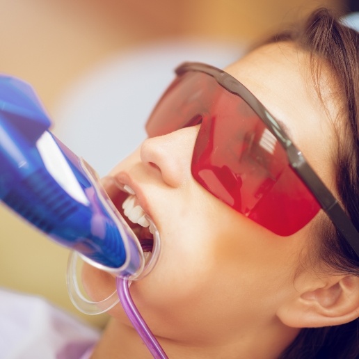 Little girl receiving fluoride treatment in dental office