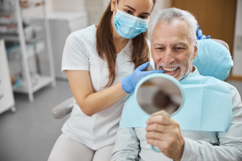 An older man happy with his new dental implant