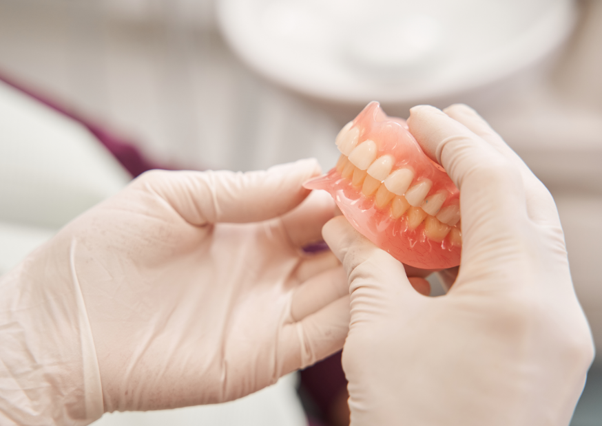Dentist holding dentures