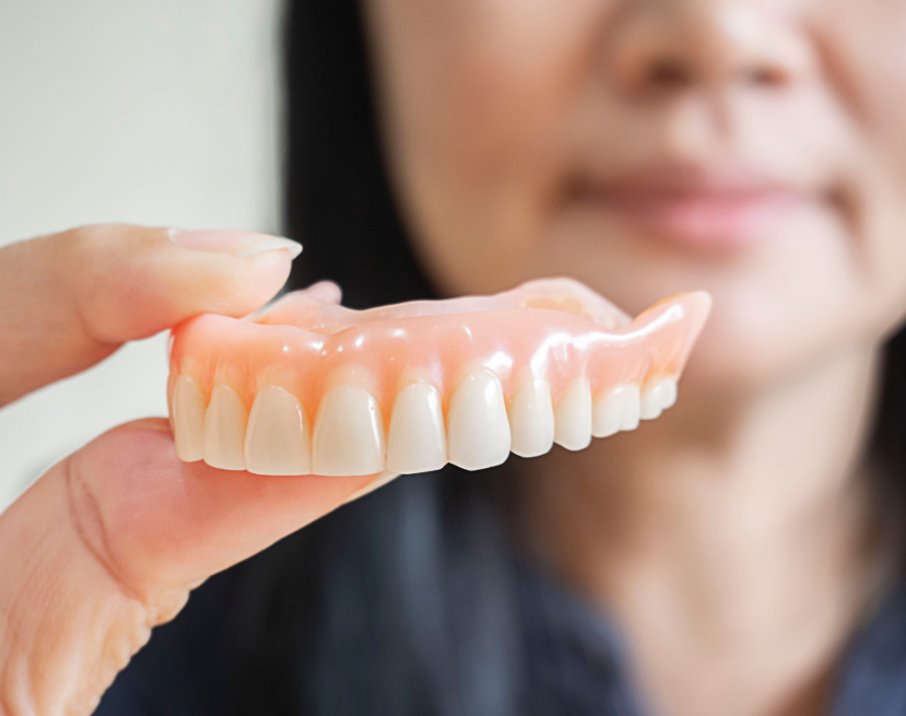 Close up of woman's hand holding denture