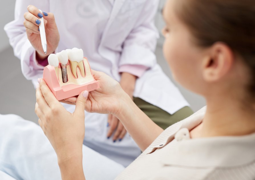 Doctor showing patient dental implant model